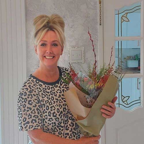 Foster carer Paula holding a bouquet of flowers