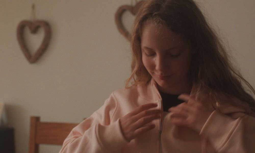 Young girl fastening her pink jacket