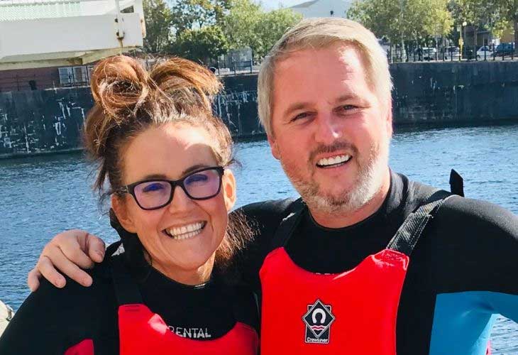 Foster carers Georgina and Vincent on holiday and wearing wet suits