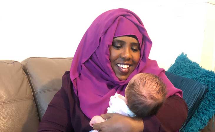 Foster carer holding newborn baby