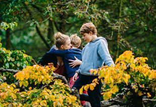 Children hugging surrounded by greenery